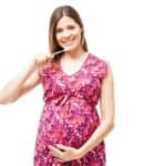 pregnant woman brushes her teeth
